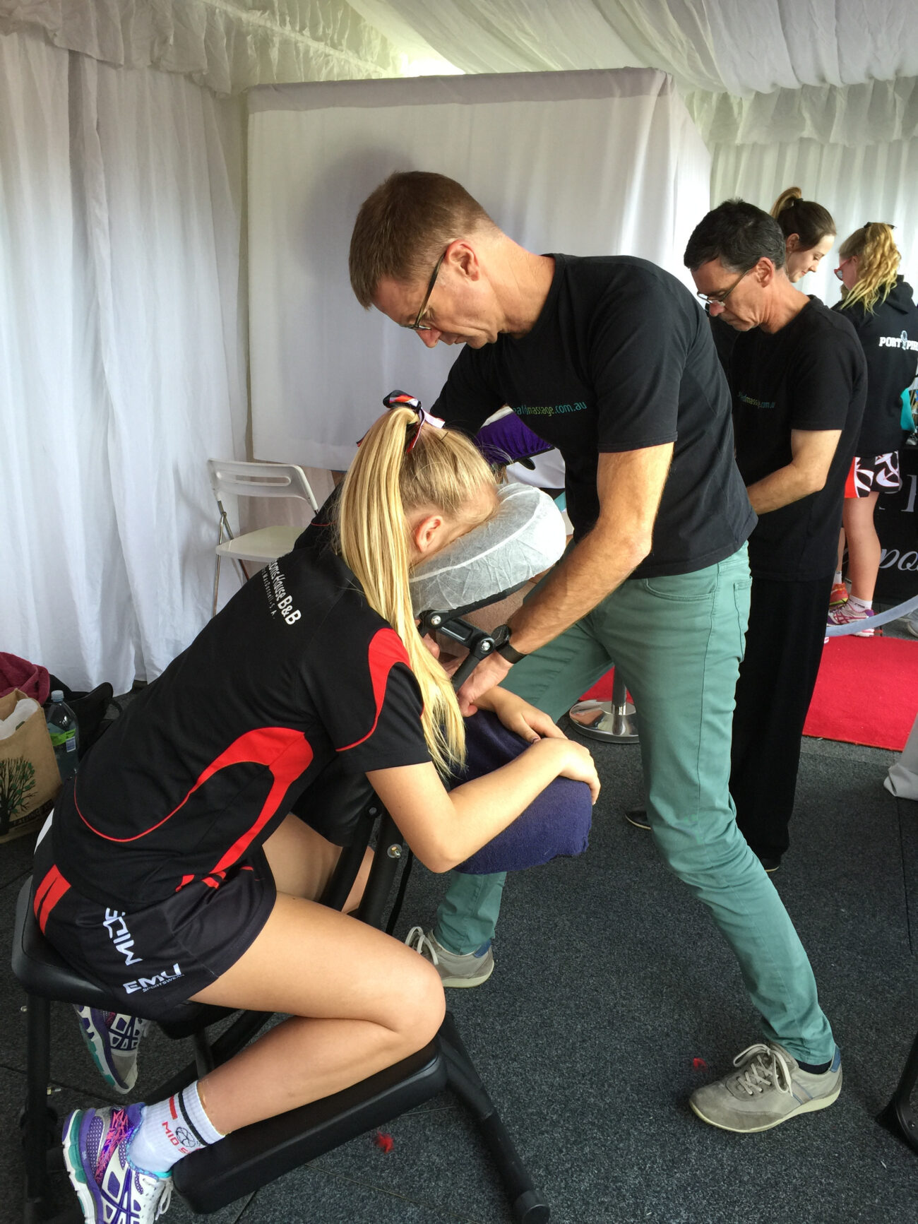 A female athlete gets a massage from Seated Massage at a sporting event