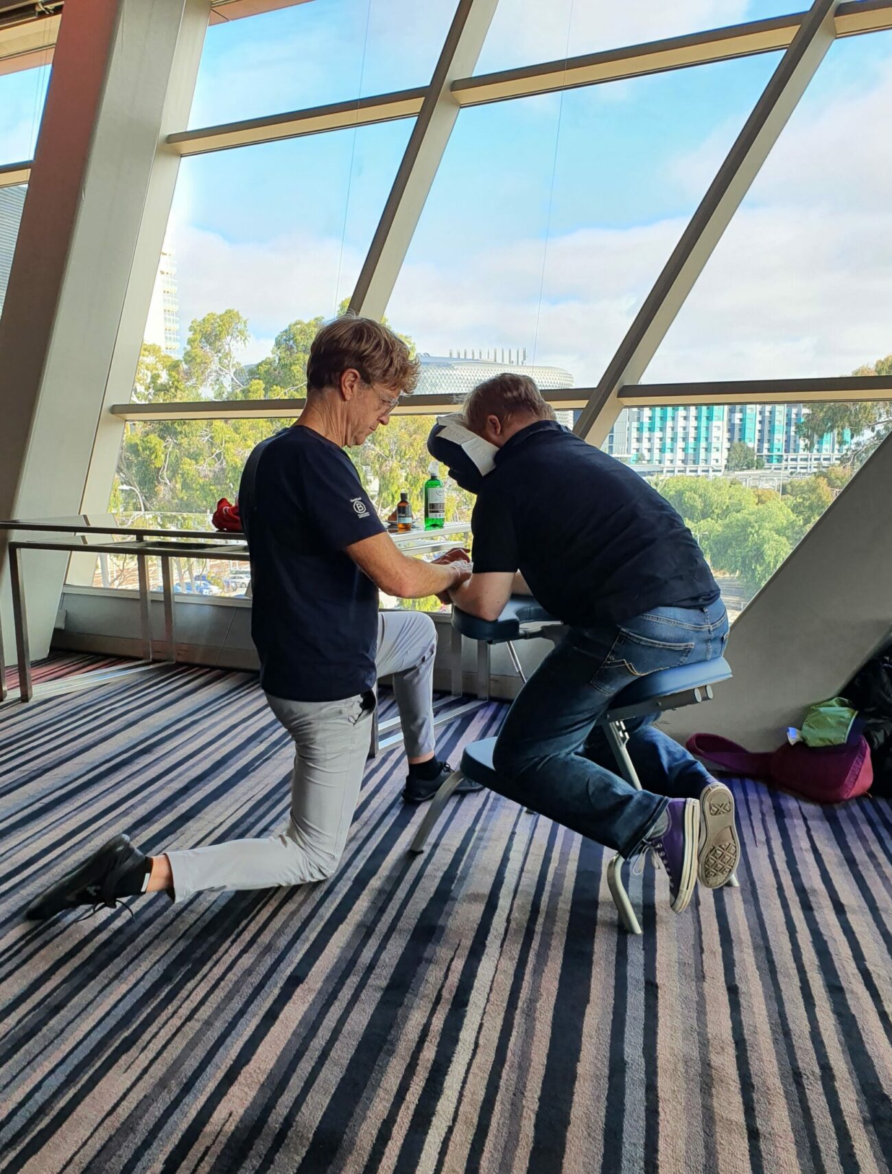 A male massage practitioner gives a conference delegate a massage